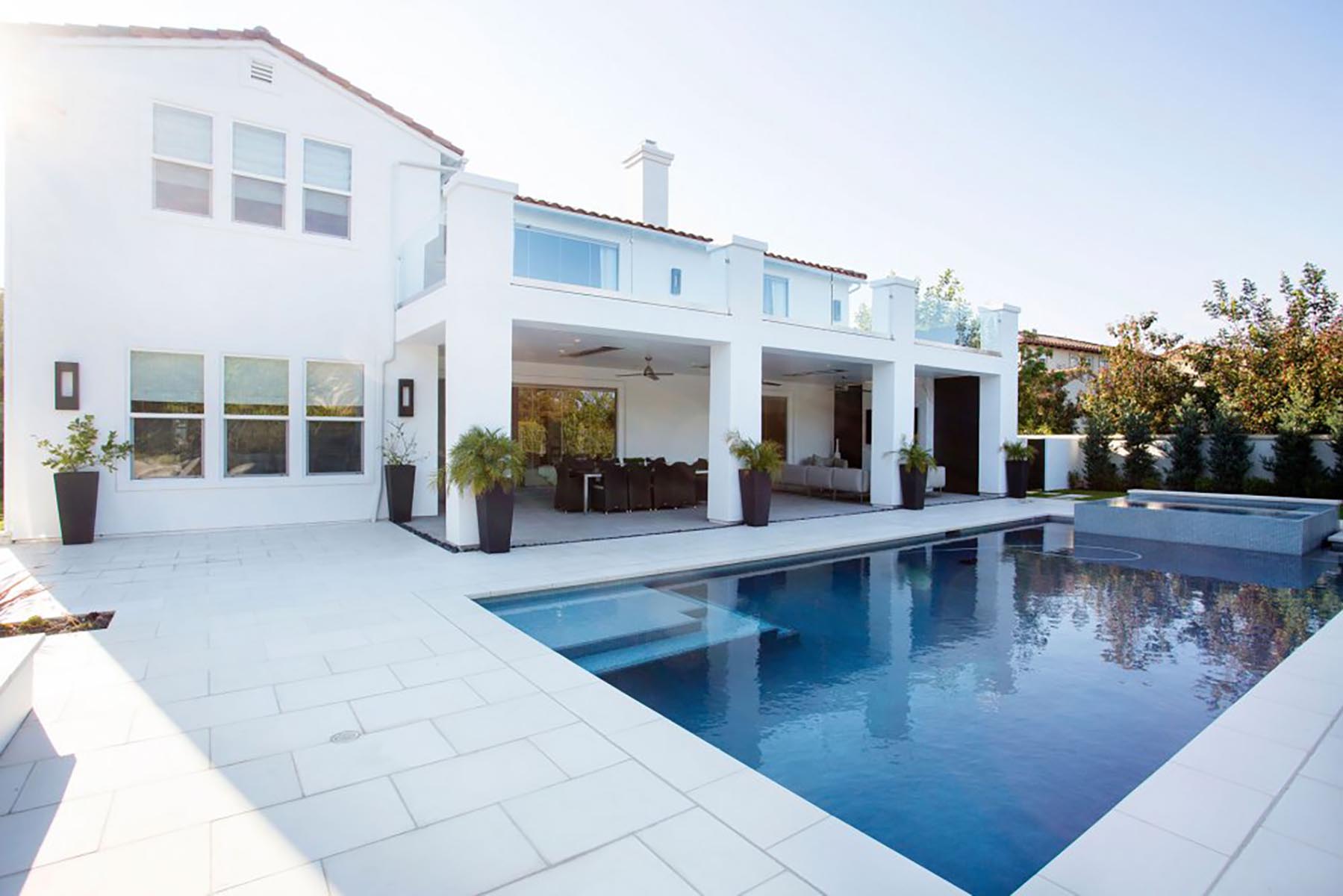 A white modern home with a large pool